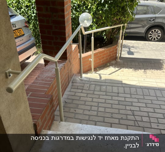 מעקה מתכת ליד מדרגות ולבנים אדומות